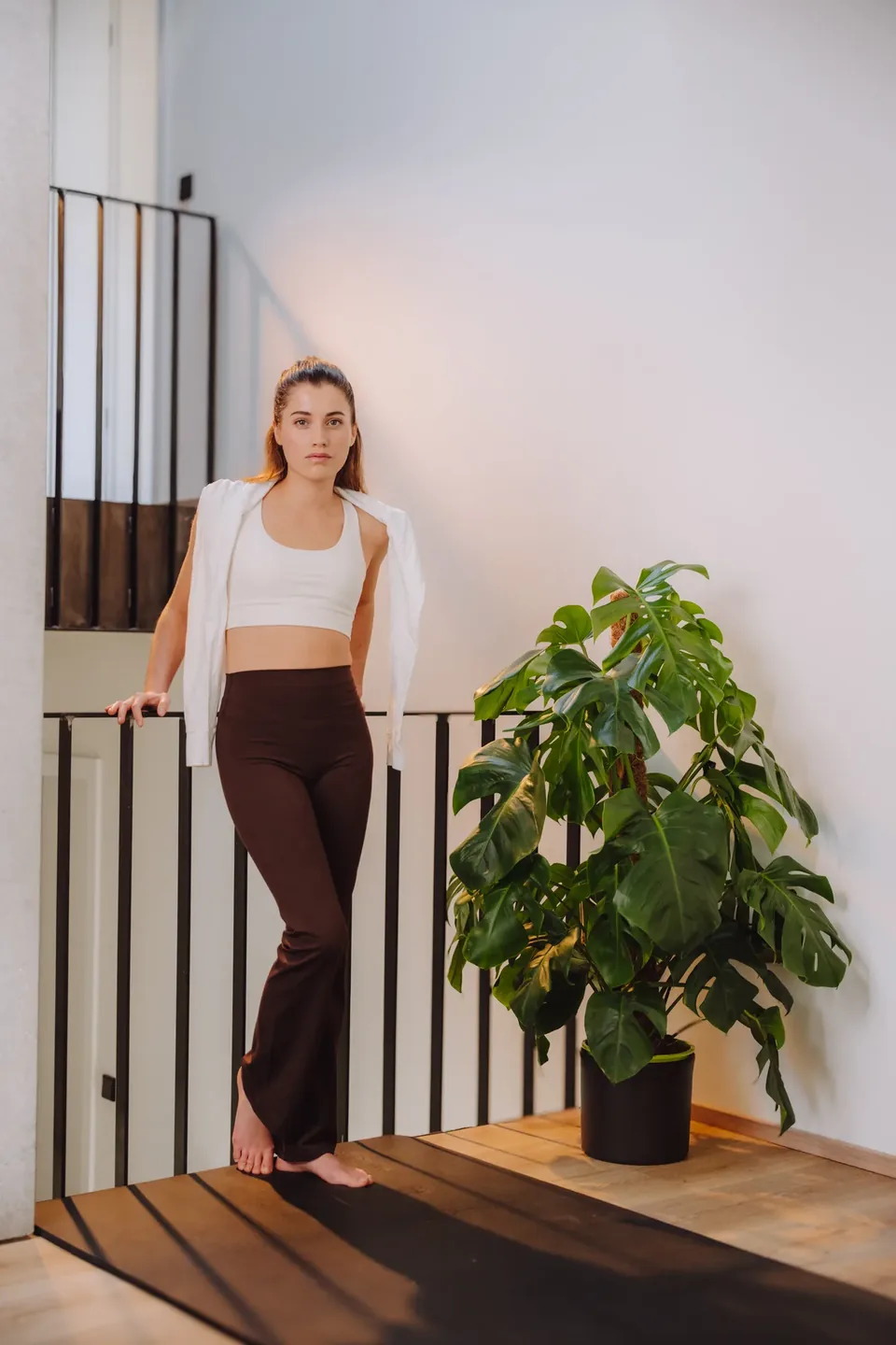 Model in Sportswear mit Monstera, Lifestyle-Fotografie Eubiona