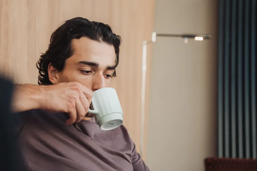 Gast trinkt Kaffee in der Lobby, nah fotografiert