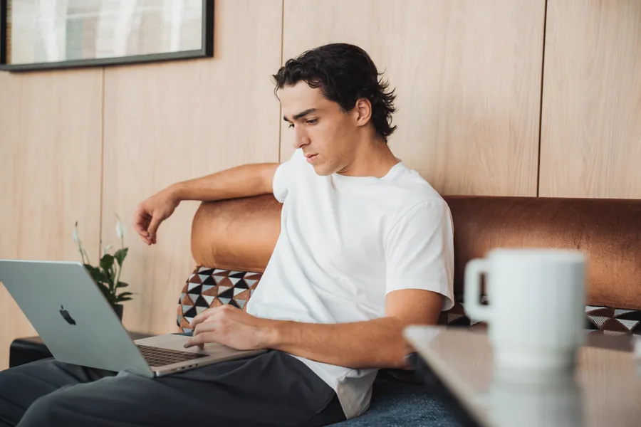 Gast arbeitet am Laptop auf dem Sofa in der Lobby