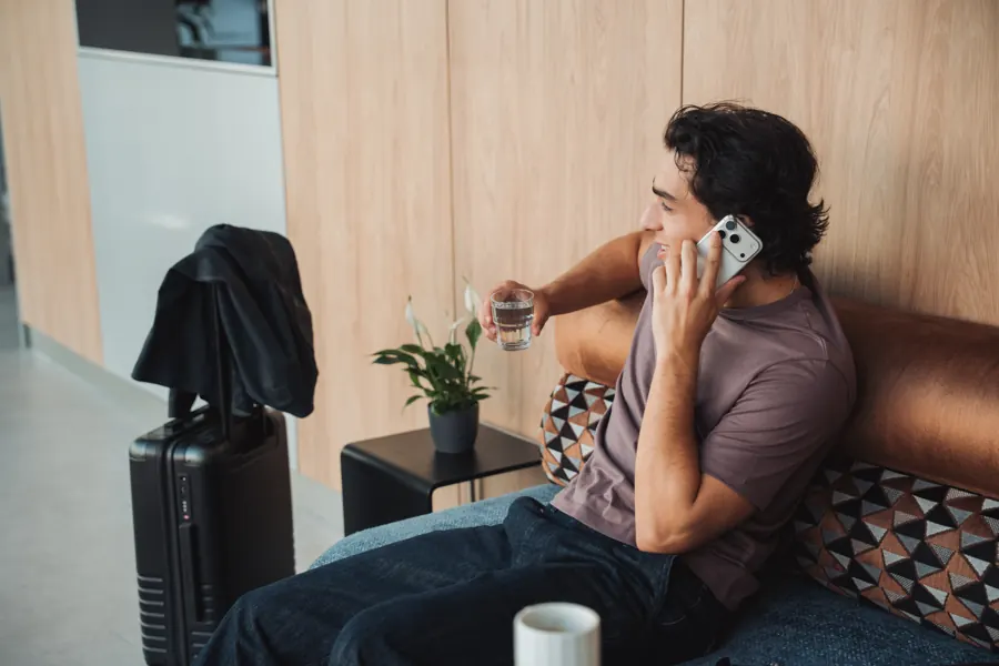 Gast telefoniert auf dem Sofa in der Lobby