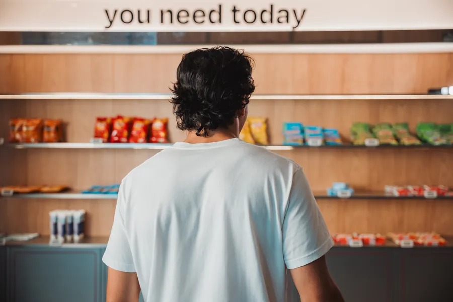 Gast vor dem Snackregal mit der Aufschrift you need today