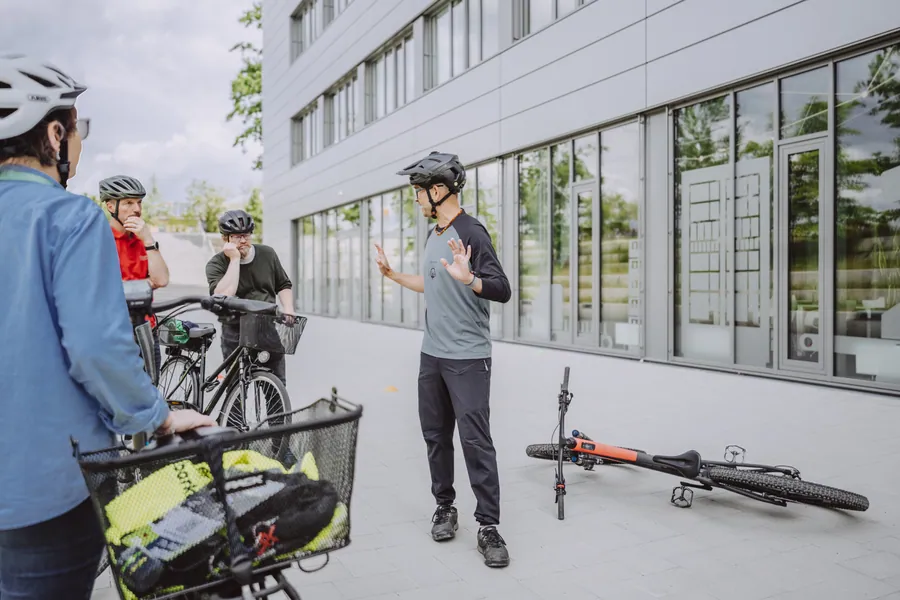 Mitarbeitende mit Fahrradhelm und Lastenrad