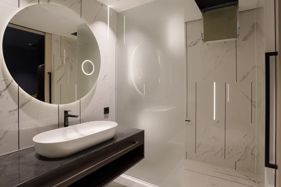 Badezimmer mit rundem Spiegel und Marmor