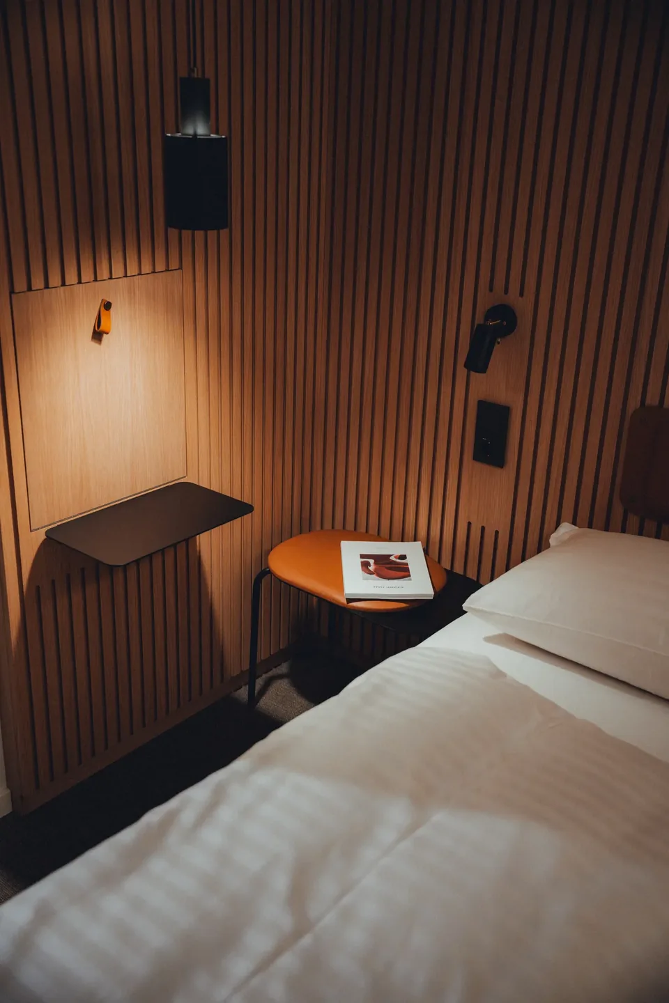 Nachttisch mit Buch im warmen Licht, Interior-Detail Zleep