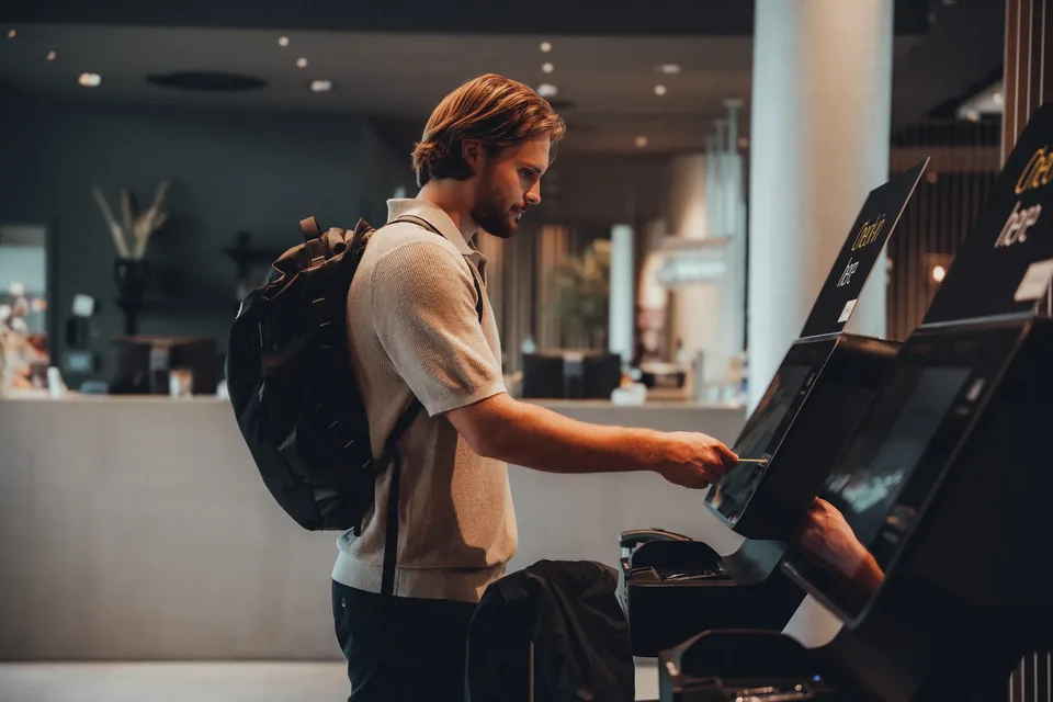 Gast am Self-Check-in-Terminal in der Lobby, Zleep Hotel